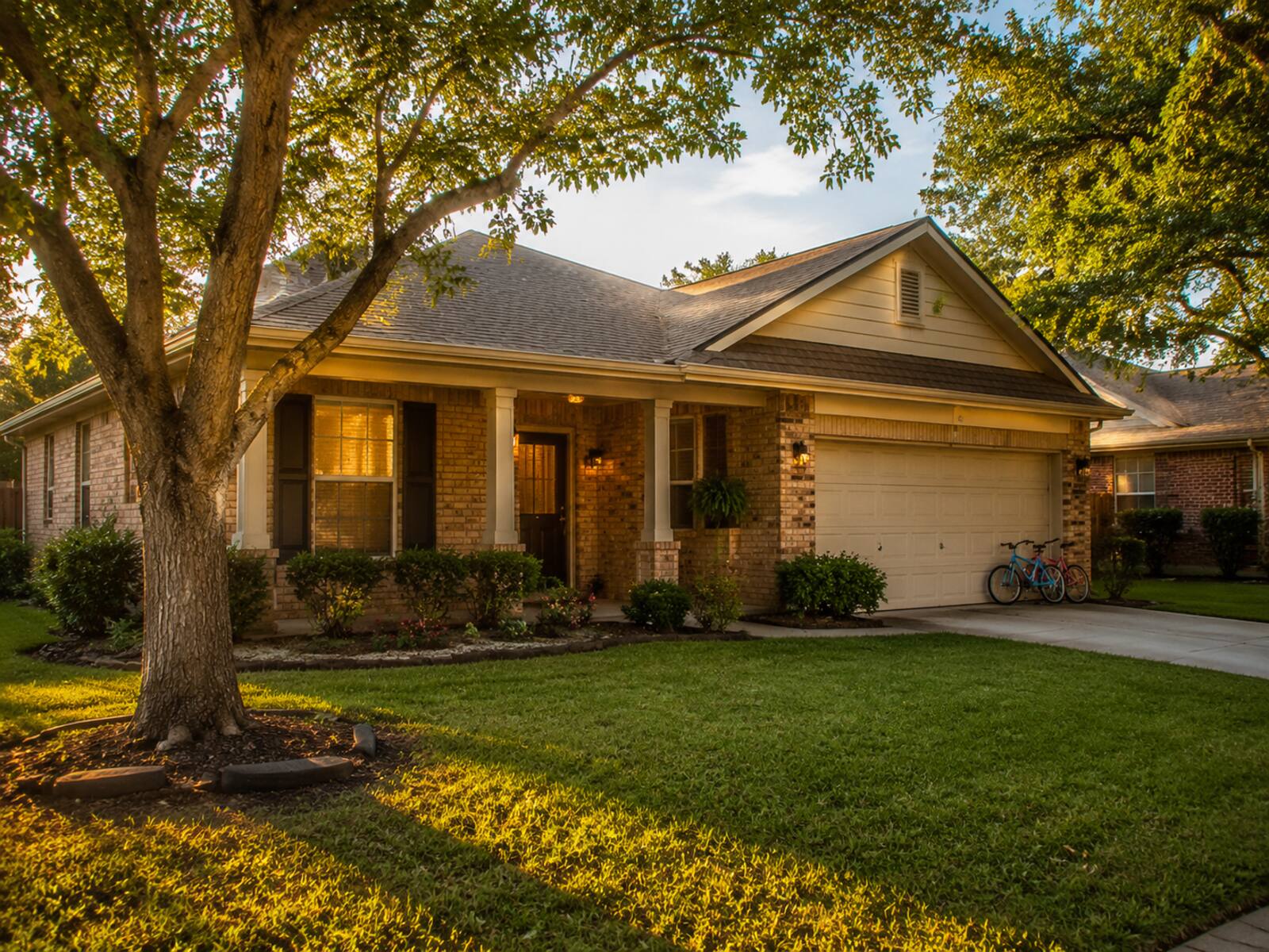 A solid brick North Houston home with bikes parked in the driveway